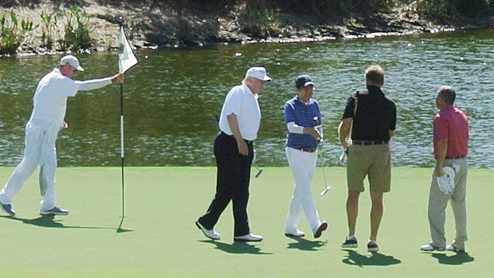 US President Donald Trump (2nd L) and Japan's Prime Minister Shinzo Abe (C) enjoy playing golf in Florida.