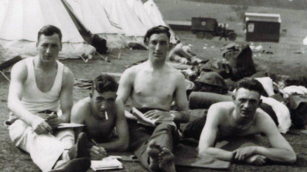 Guardsman David Blyth, second from left, relaxes with unknown comrades