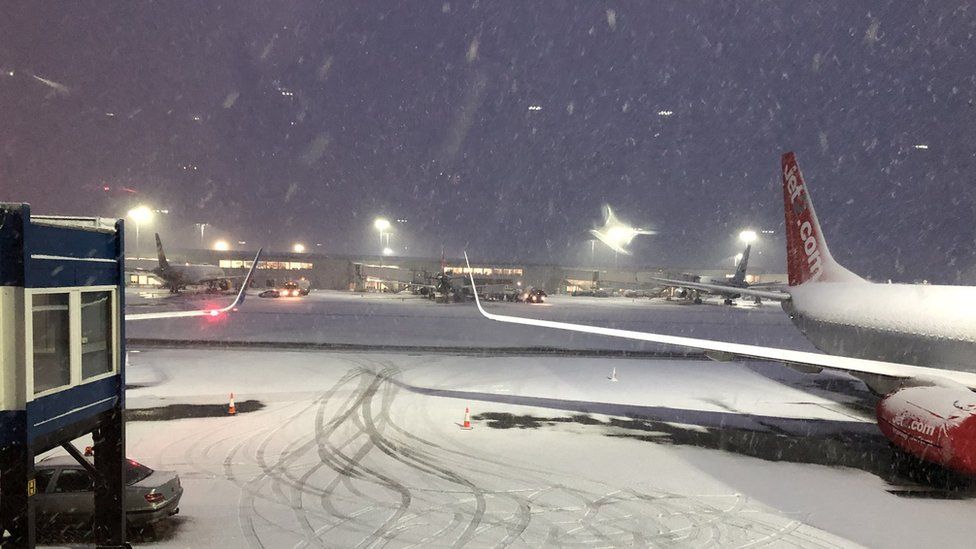 Snow falling on a plane and runway