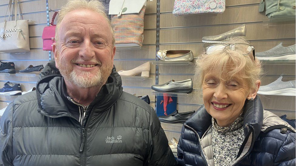 Siblings Paul and Nuala smile for the camera in their shoe shop