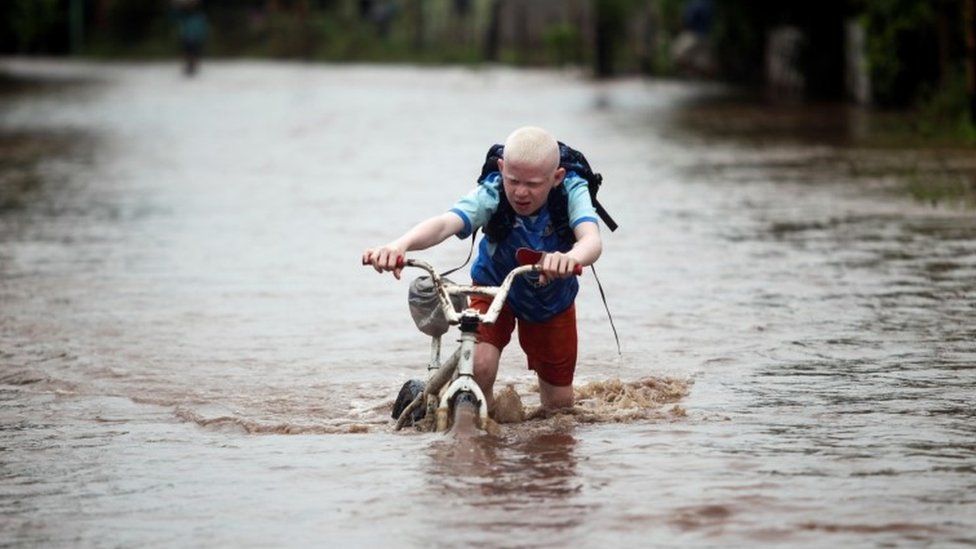 A child pushes his bicycle through a flooded road in Honduras
