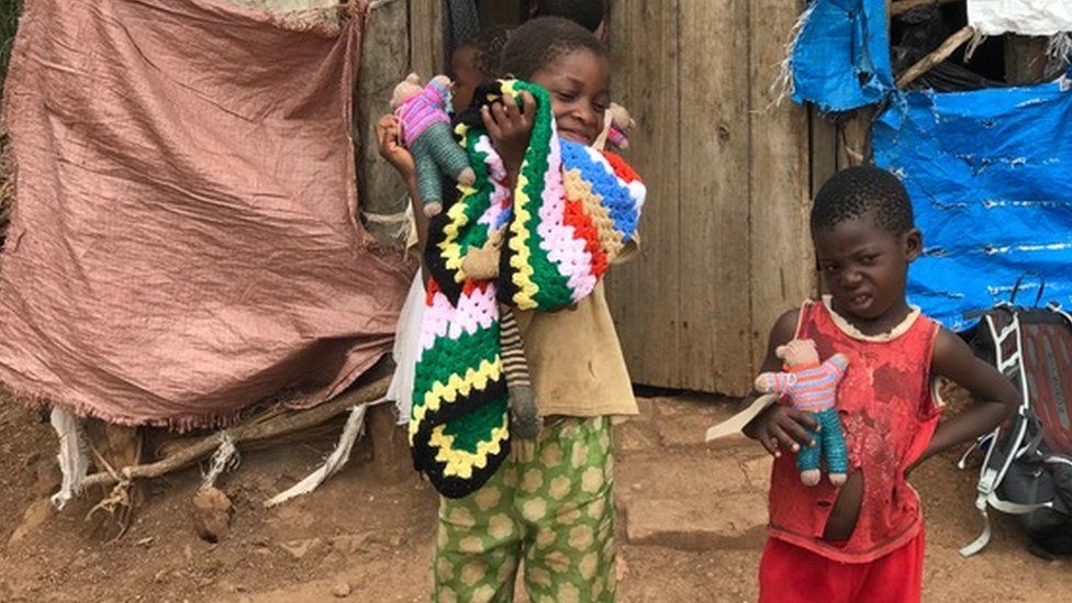 Children in Africa with knitted teddies