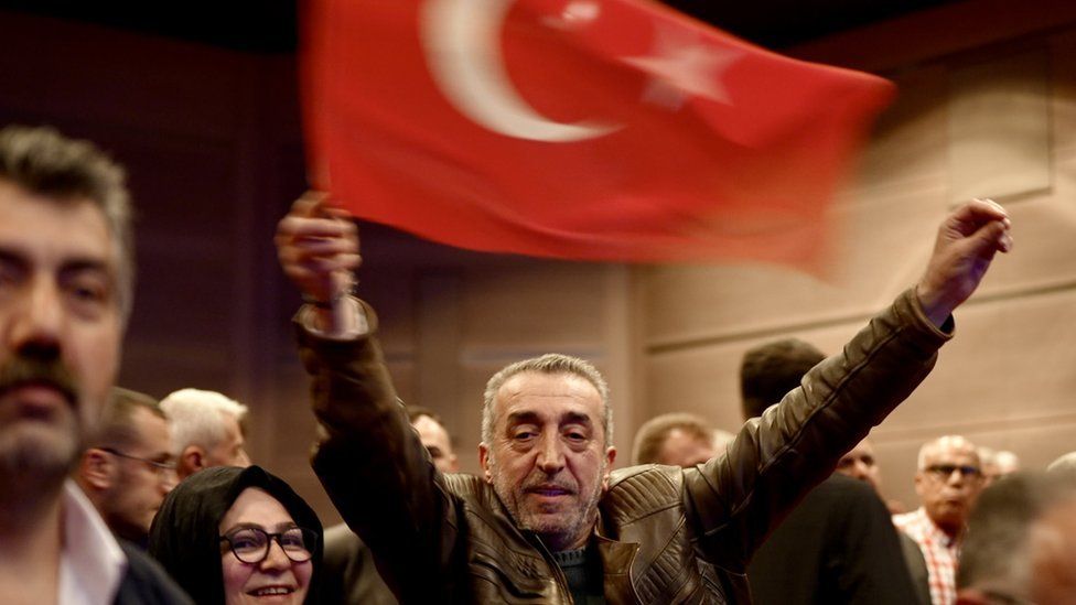 A supporter of President Erdogan waves a Turkish flag at a taxi driver convention