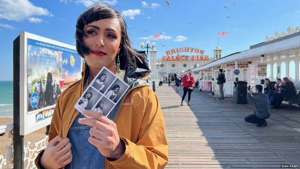 Bella holds up a photograph of herself on Brighton Pier