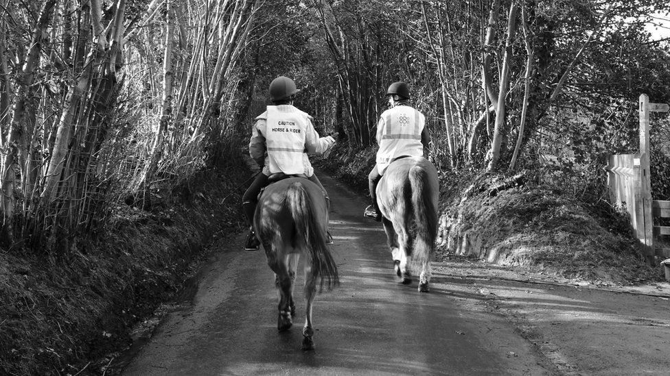 Two horse riders on a country lane
