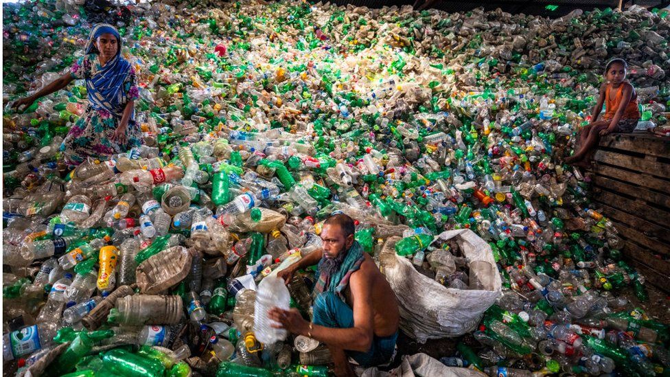 Labourers sort through polyethylene terephthalate (PET) bottles in a recycling factory in Dhaka, Bangladesh, on May 5, 2021.