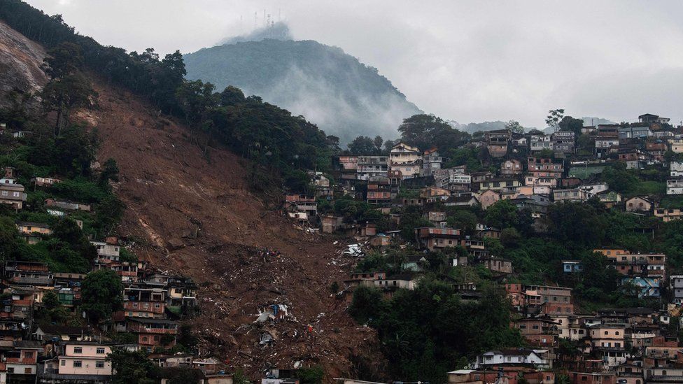 An emergency service helicopter flies over a large landslide caused by severe flash floods in Petropolis