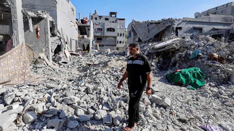 Palestinian man walks amid the rubble of his home in Khan Younis which was destroyed, killing 35 members of his extended family.