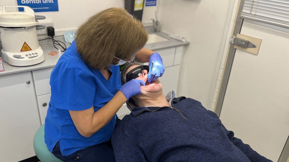 Dentist treats patient on mobile dental unit