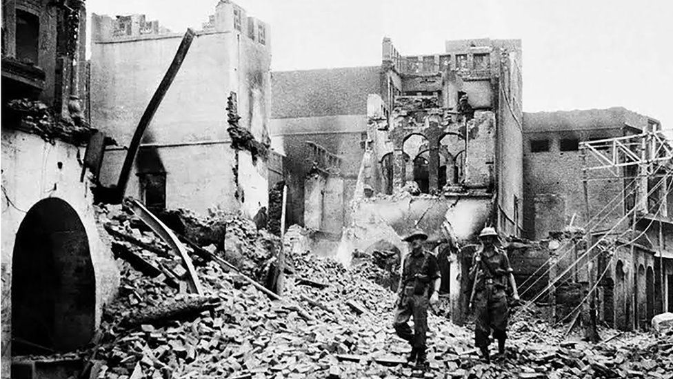 Indian soldiers walking through the debris of a building in Amristar in August 1947