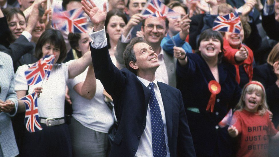 Tony Blair arriving in Downing Street after Election Victory, London with crowds waving flags in the background.