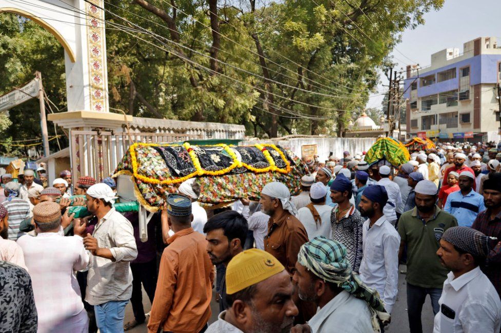 Люди несут гробы с телами жертв для их захоронения после обрушения подвесного моста в городе Морби в западном штате Гуджарат, Индия, 31 октября 2022 г.