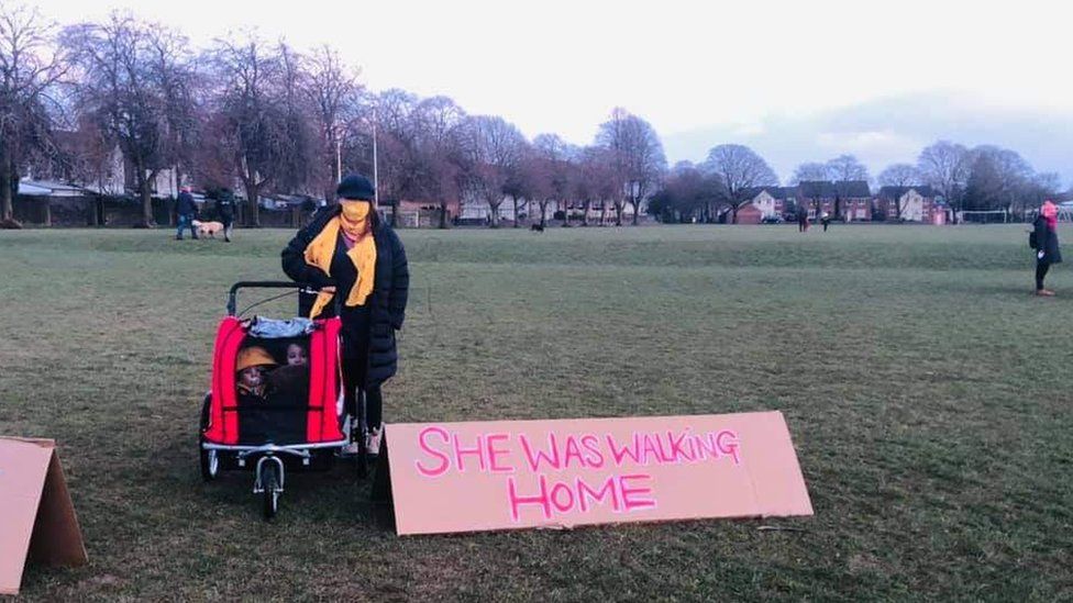 A protester on Hailey Fields in Llandaff North with a placard: "She was walking home"