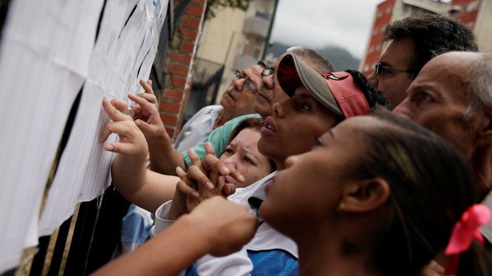 People check a list at a polling station during a nationwide election for new mayors, in Caracas, Venezuela December 10, 2017.