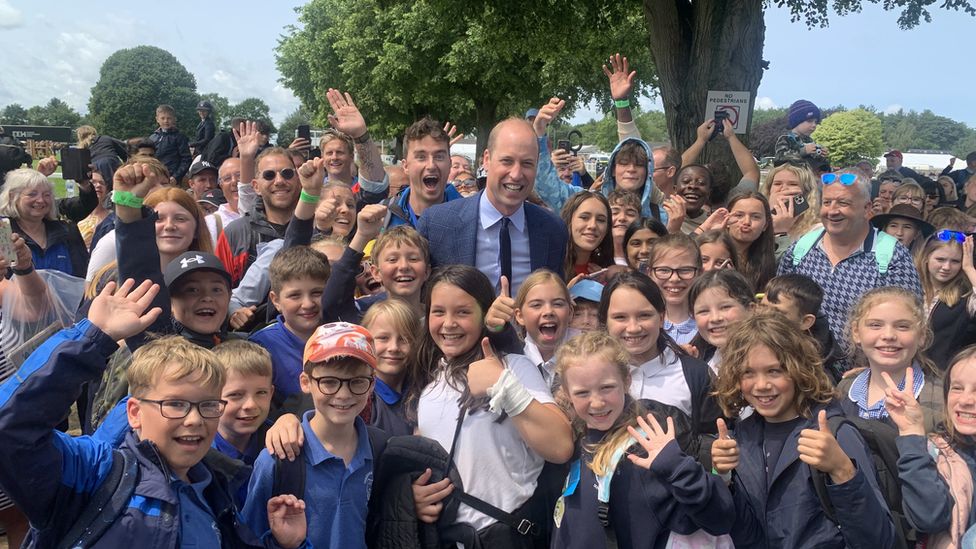 Prince William in the middle of a group of children from Hingham Primary School