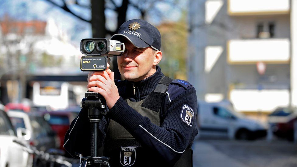 A German police officer holds a portable laser speed trap to his eye in this 2016 file photo
