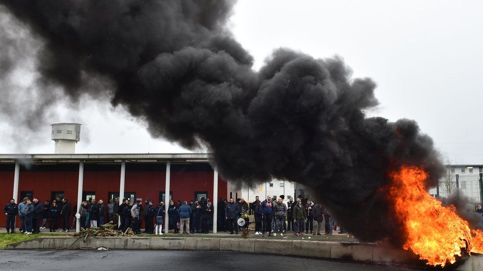 Waste burns as prison guards block the entrance to the penitentiary center of Alencon, in Conde-sur-Sarthe,
