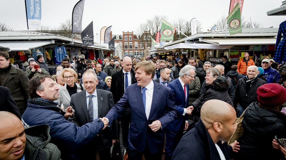 Dutch King Willem-Alexander (C) shakes hands at the Haagse Markt during his surprise visit in the Transvaalkwartier and Schilderswijk districts in The Hague on 23 March 2016.