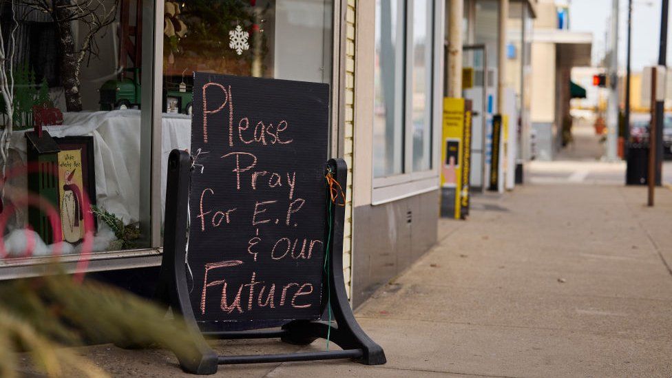 Foto de un cartel fuera de un negocio en Palestina Este que dice 'Por favor, recen por E.P. and our future.andquot;