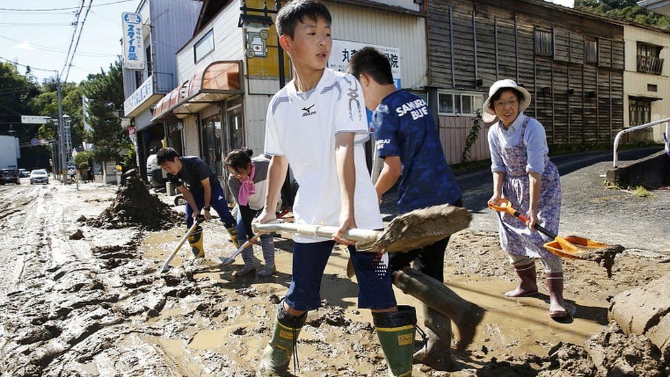 Schoolchildren and residents remove mud after flooding caused by Typhoon Hagibis in Marumori, Miyagi prefecture, Japan, October 13, 2019