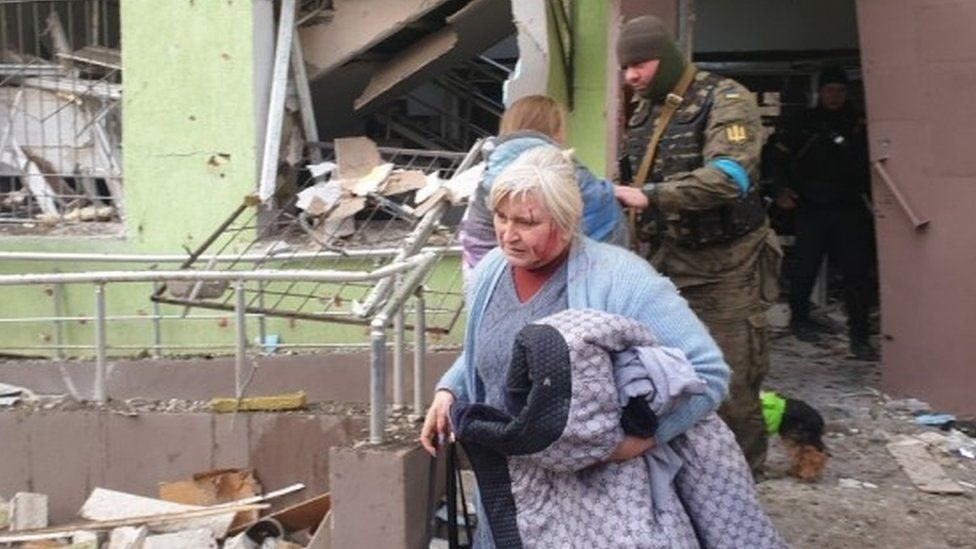 A woman carries her belongings following a Russian strike in Mariupol
