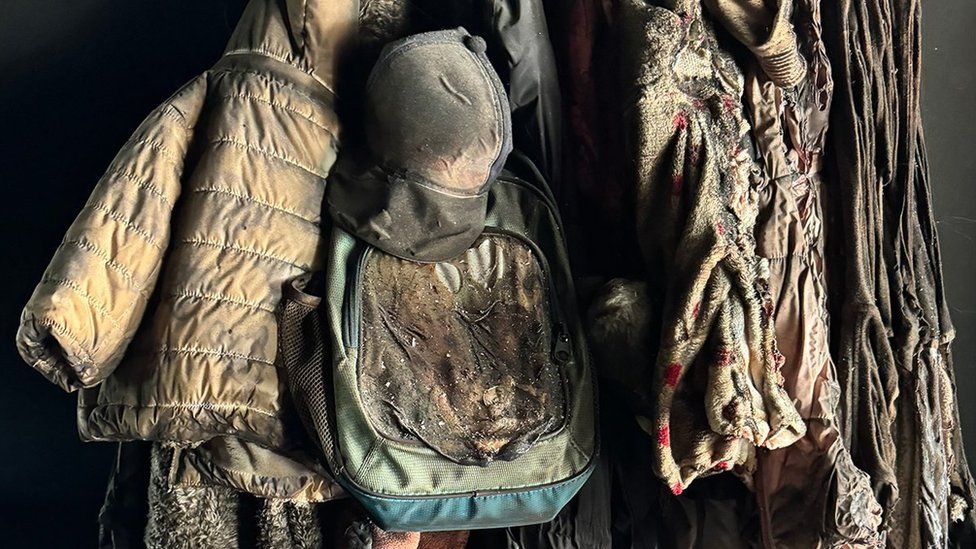 Children’s jackets and a schoolbag still hang on the wall of one burned-out home