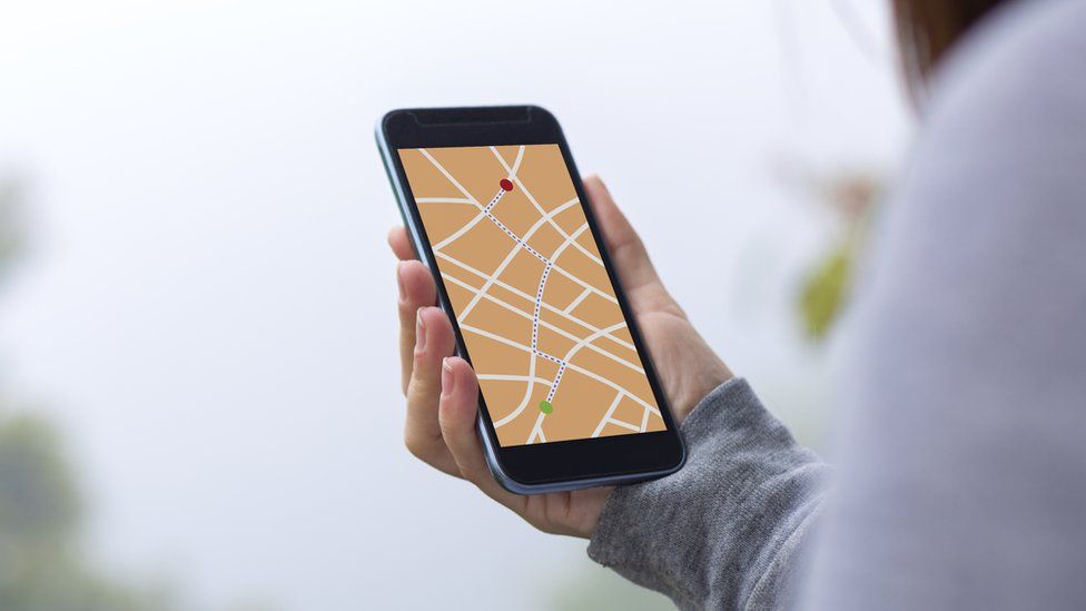 Young woman using GPS map direction on smartphone app.