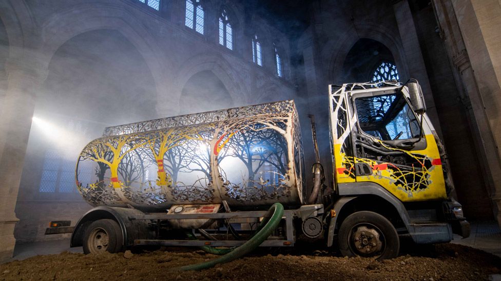 An old petrol tanker lorry has been carved up so that its sides and tank now take on the ethereal shapes of trees.