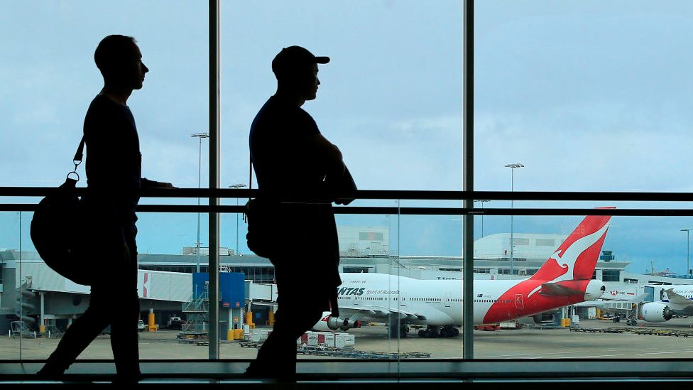 Passengers walk through an airport in Australia