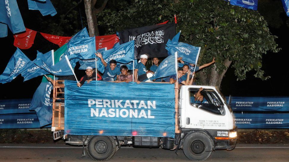 Перикатан Национал приветствует из кузова грузовика накануне всеобщих выборов в Малайзии в Перматанг Паух, Пенанг, Малайзия, 18 ноября 2022 г.