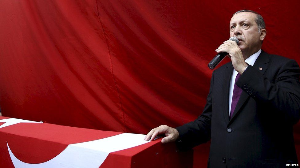 Turkish President Tayyip Erdogan speaks next to the flag-draped coffin of slain police officer Ahmet Camur, who was killed during clashes with PKK militants, during a funeral ceremony in Trabzon, Turkey, 16 August 2015