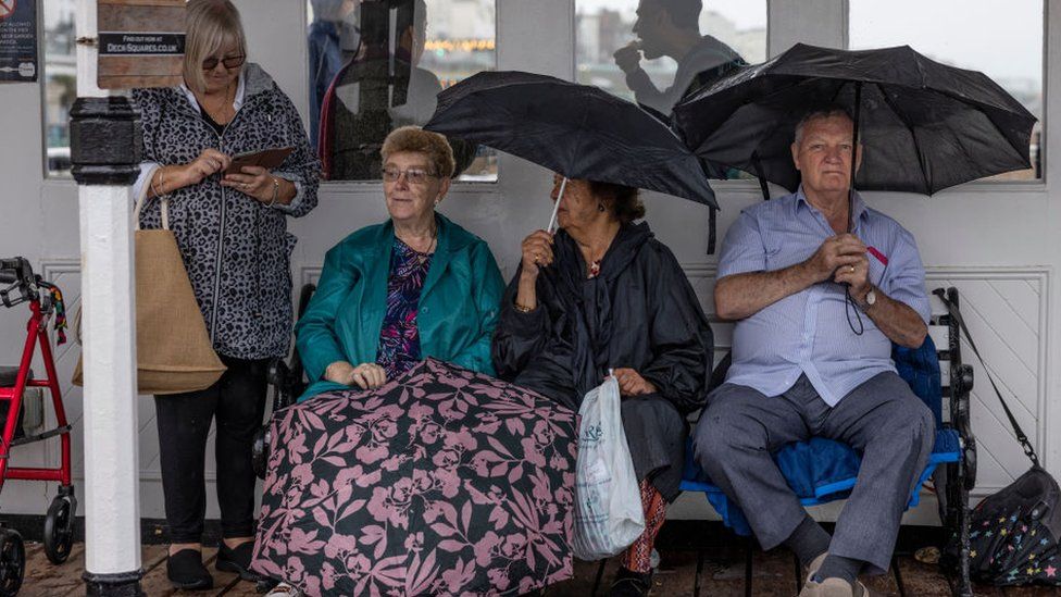 Daytrippers shelter from a downpour at Brighton Pier on Wednesday