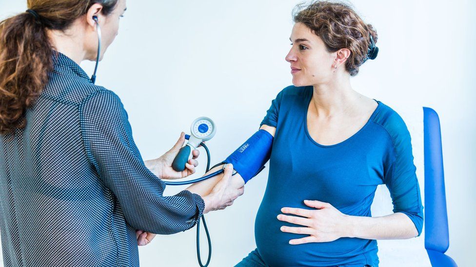 Doctor takes pregnant woman's blood pressure