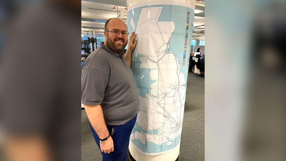 Dave Jones by a map of the railway system in Great Britain