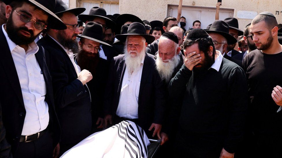 Men mourn at the funeral of Avishai Yehezkel, an Israeli man who was killed in a gun attack in Bnei Brak, Israel (30 March 2022)