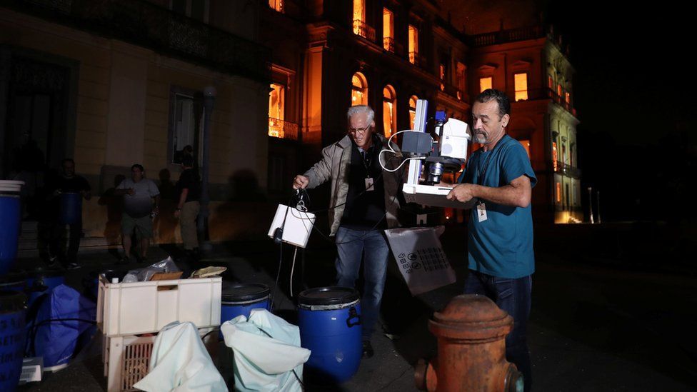 Dos hombres sacando objetos del Museo.