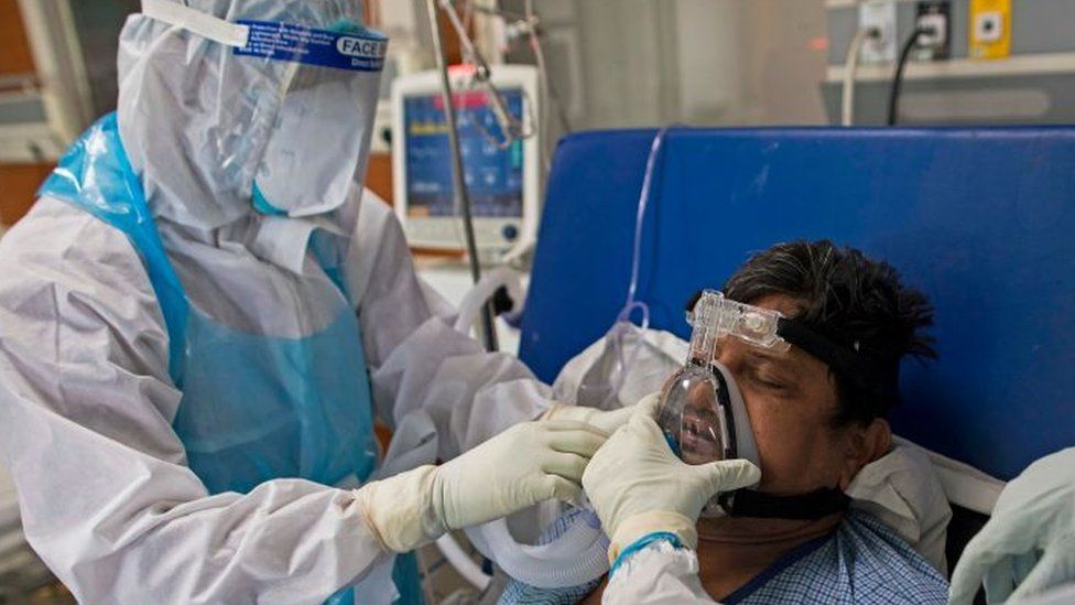 A doctor and a nurse wearing Personal Protective Equipment (PPE) suits look after a COVID-19 coronavirus patient at the Intensive Care Unit of the Sharda Hospital, in Greater Noida. -