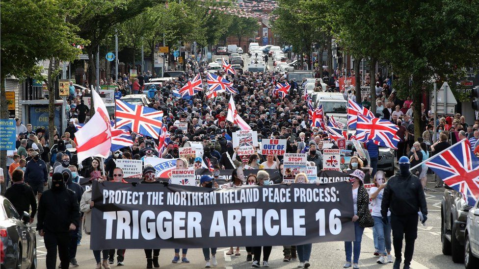 Hundreds of people walk along the Shankill Road in Belfast, carrying union flags, placards and banners, to protest against the Northern Ireland Protocol