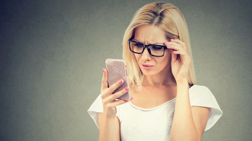 Woman looking confused at her phone