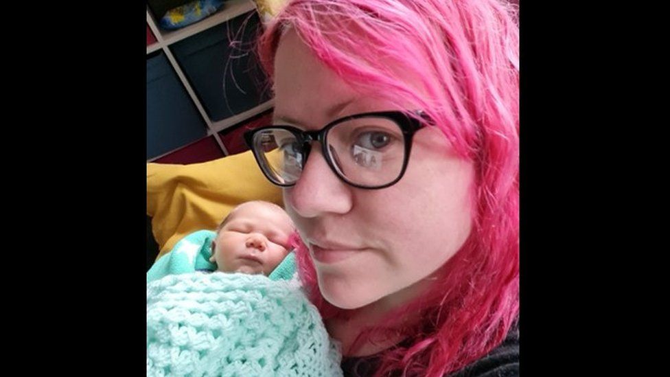 Seaneen Molloy with pink hair holding her baby, Jack