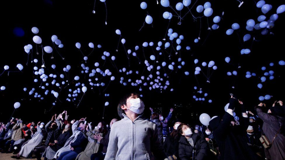 Гуляки запускают воздушные шары, принимая участие в праздновании Нового года в Токио, Япония