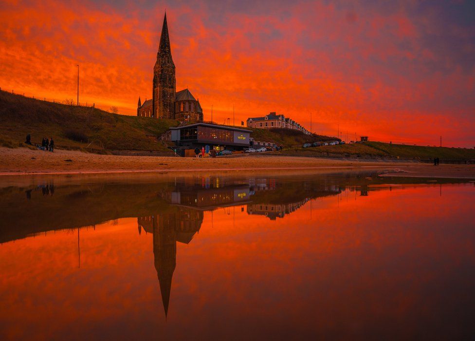 Tynemouth's Longsands beach and St George's Church reflected in water