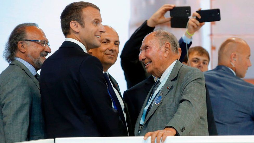 French President Emmanuel Macron (2ndL) listens to Dassault Aviation CEO Eric Trappier (C) and Dassault Chairman Serge Dassault (R) while visiting the Paris Air Show in Le Bourget, north of Paris, on June 19, 2017.
