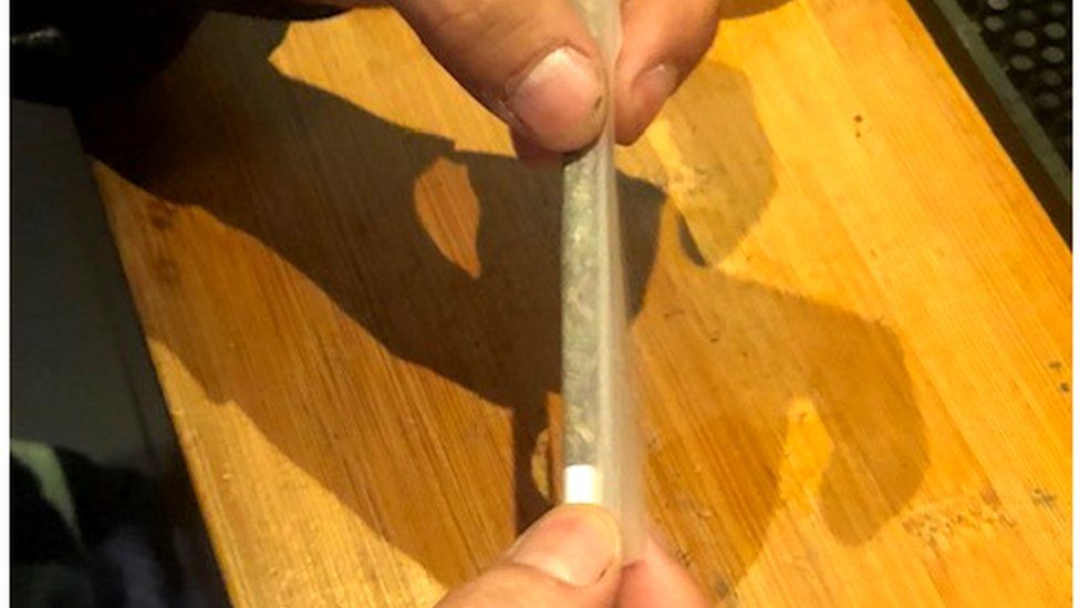 A man rolls a cannabis cigarette at a coffee shop in The Hague