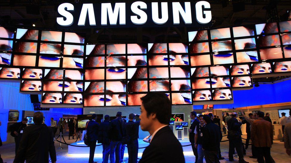A Samsung logo appears above television screens at an electronics trade fair