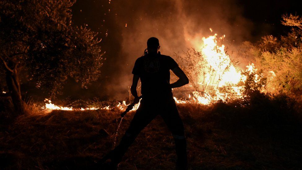 A firefighter tries to extinguish a wildfire burning in the village of Vasilika, on Evia island, Greece, August 7, 2021. REUTERS/Alexandros Avramidis