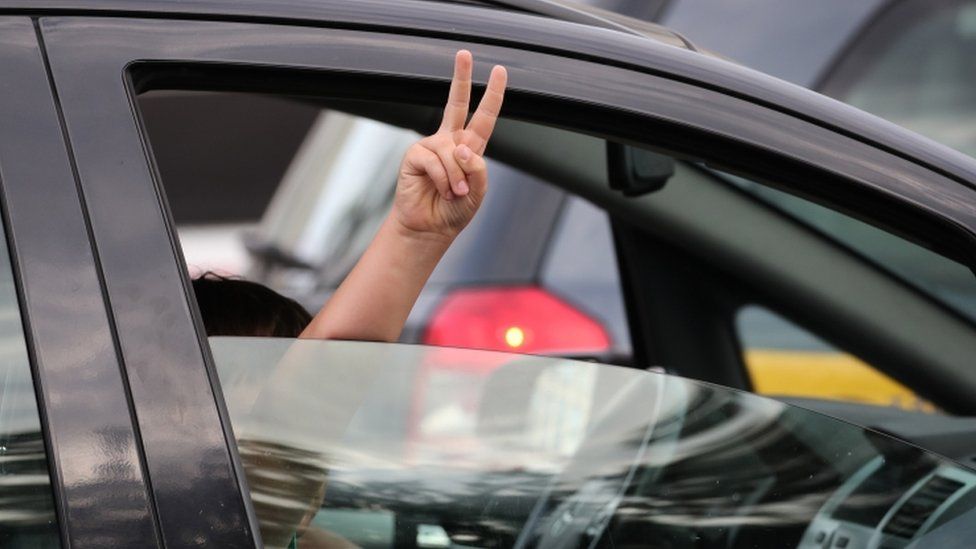 A protester shows a victory sign from a car during a rally in Minsk, Belarus