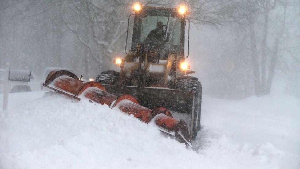 A snow plough moves snow in Cohasset, Massachusetts