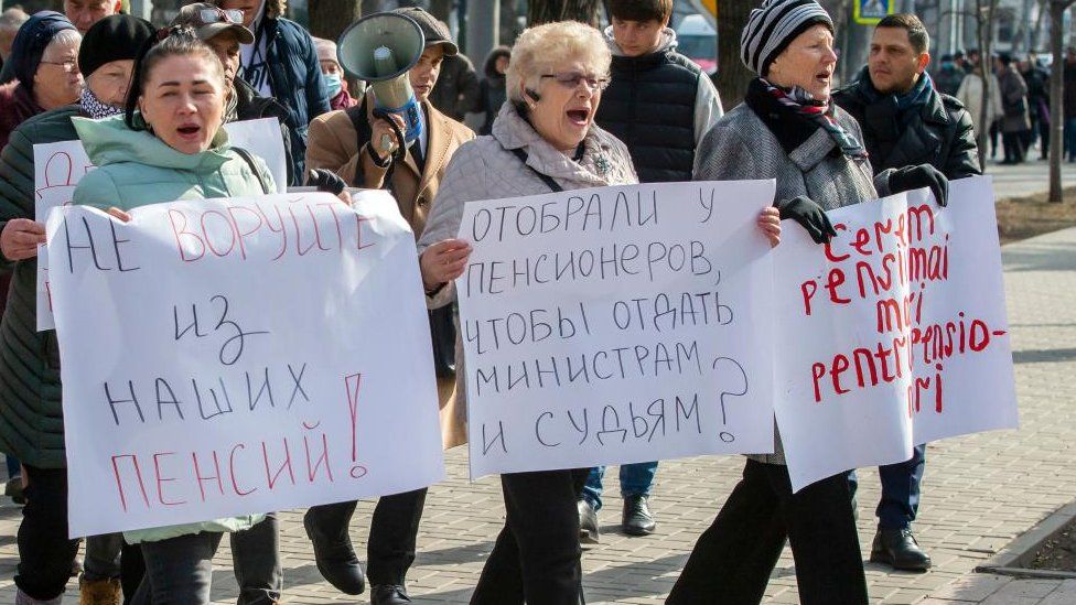 Sostenitori del partito politico Shor protestano con cartelli che recitano 'Non rubate dalla nostra pensione', 'Chiediamo l'aumento della pensione', 'Tolta ai pensionati, data agli avvocati' davanti al palazzo del Parlamento a Chisinau, in Moldavia, 23 febbraio 2023