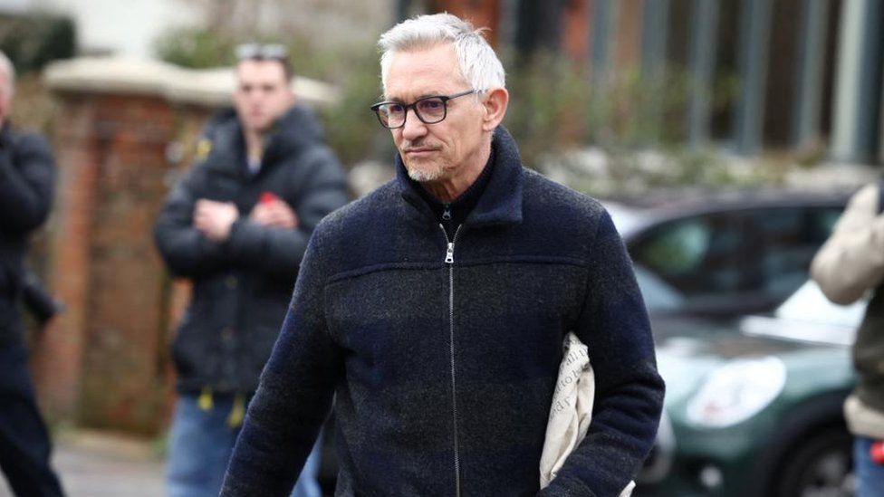Gary Lineker walking outside his home with members of the press behind him
